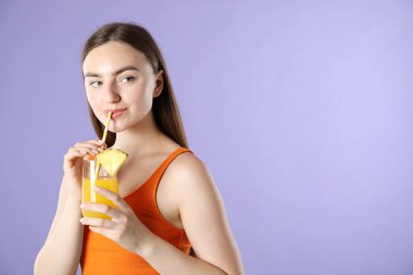 Kadın menekşe arka planında samandan ferahlatıcı içecek içiyor, metin için yer var.