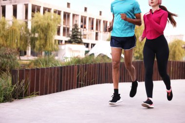 Spor giyimli bir çift dışarı koşuyor, yakın plan. Metin için boşluk