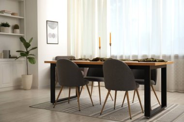 Yemek odasında sandalyeleri olan ahşap bir masa.