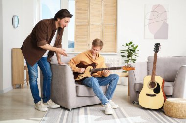 Öğretmenim evde gitar çalmayı öğretiyor.