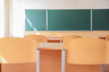 Sınıfta sandalyeli ve yeşil karatahtalı masalar