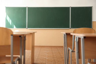 Sınıfta sandalyeli ve yeşil karatahtalı masalar