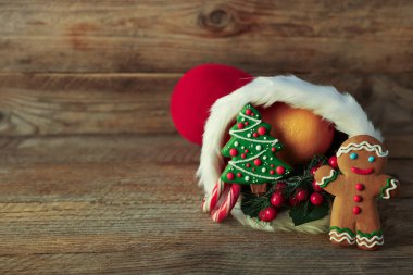 Aziz Niklas Günü geleneği. Şekerli kırmızı çizme ve ahşap masada şenlikli dekor, metin için yer