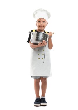 Meslek seçimi. Ot ve kaşıkla beyaz arka planda şef gibi davranan küçük çocuk