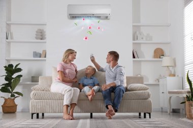 Aile evdeki klimayı uzaktan kumandayla kontrol ediyor.