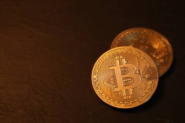 Kripto para birimi. Altın Bitcoin siyah masada, yakın plan. Metin için boşluk
