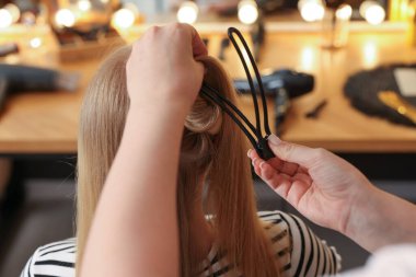 Profesyonel kuaför müşteriyle kuaförde çalışıyor.