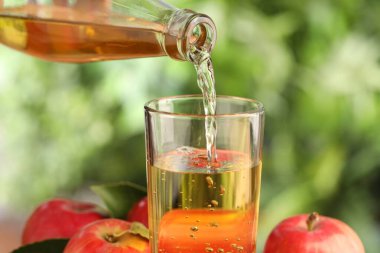 Lezzetli elma şarabını bulanık arka plana dökmek, yakın plan