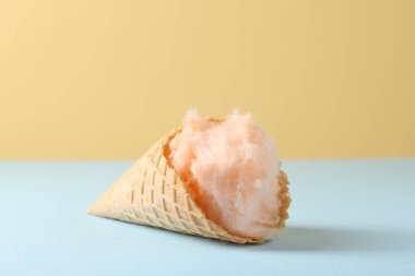 Renkli arka planda pamuk şekerli waffle külahı, yakın plan