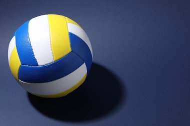Mavi arka planda renkli bir voleybol topu. Metin için boşluk