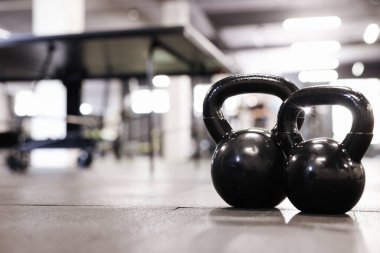 Spor salonunda yerde siyah çaydanlık, yakın plan. Metin için boşluk