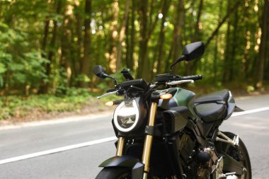 Modern siyah motosiklet açık yolda park edilmiş. Metin için boşluk