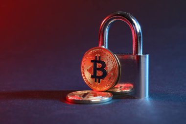 Mavi arkaplanda kırmızı ışıkta bitcoinler ve asma kilit, metin için boşluk ile yakın çekim