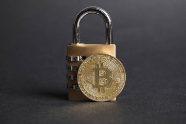 Gri arkaplanda Bitcoin ve asma kilit, yakın plan