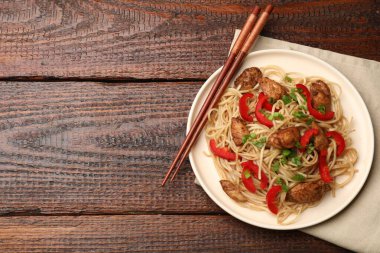 Tavuk, yeşil soğan ve sebzeli lezzetli şehriyeler ahşap masada servis edilir. Metin için boşluk