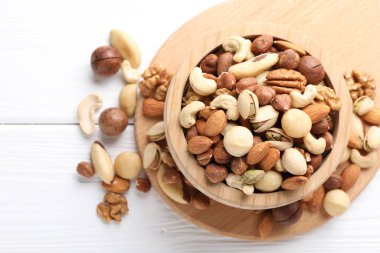 Beyaz ahşap masadaki kasede farklı fındıkların karışımı. Metin için boşluk