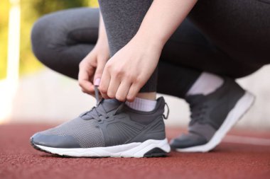 Koşucu ayakkabısının bağcıklarını bağlıyor, yakın plan.