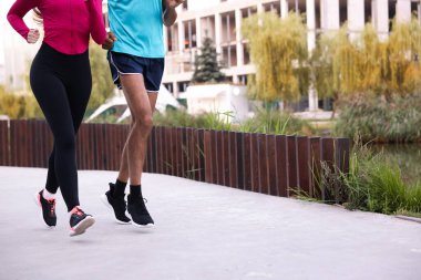 Spor giyimli bir çift dışarı koşuyor, yakın plan. Metin için boşluk