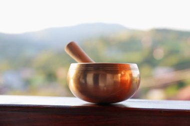 Tibet şarkı kasesi. Tırabzanda tokmak var. Açık havada.