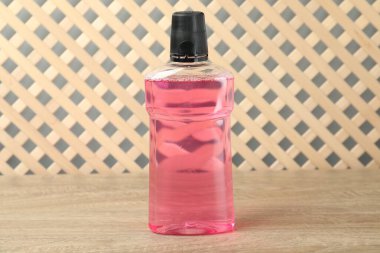 Ahşap masada bir şişe gargara. Ağız temizliği.