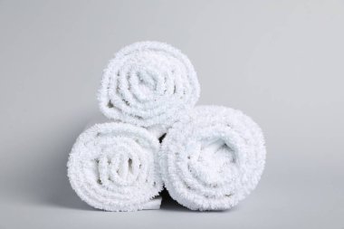 Gri arka planda yuvarlanmış havlular, yakın plan.