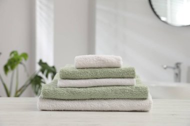 Katlanmış havlular banyodaki açık ahşap masada, yakın plan.