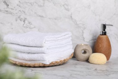Mermer masa üzerinde beyaz havlu ve tuvalet malzemeleri yığını