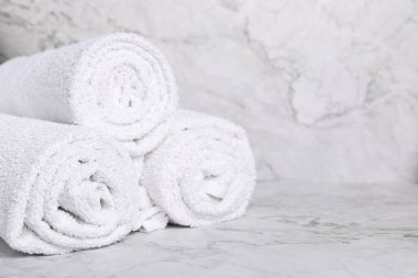 Mermer masada yuvarlanmış beyaz havlu, yakın plan. Metin için boşluk