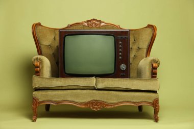 Retro TV seti ve zeytin arka planda kanepe. Kullanılmış eşyalar