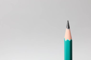 Gri arka planda keskin bir grafit kalem, yakın plan. Metin için boşluk