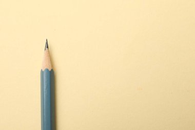 Bej arka planda keskin bir grafit kalem, üst manzara. Metin için boşluk