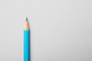 Gri arka planda keskin bir grafit kalem, üst manzara. Metin için boşluk