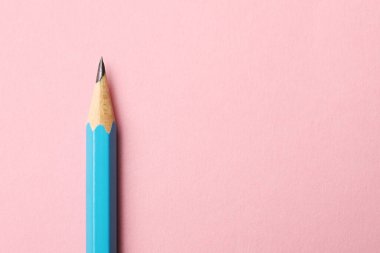 Pembe arka planda keskin bir grafit kalem, üst manzara. Metin için boşluk