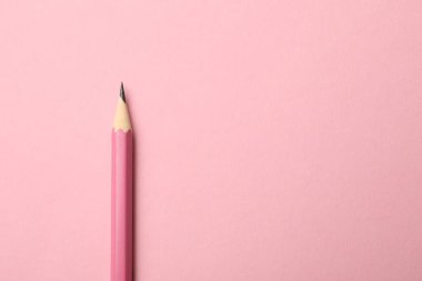 Pembe arka planda keskin bir grafit kalem, üst manzara. Metin için boşluk