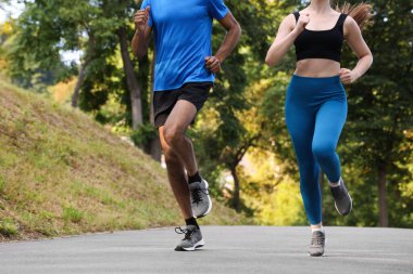Spor giyimli bir çift parkta koşuyor, yakın plan. Metin için boşluk