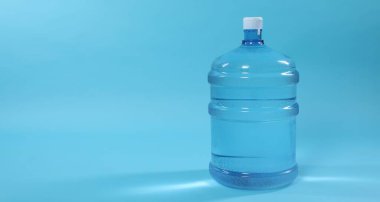 Açık mavi arka planda su bulunan soğutucu şişesi, yakın plan. Metin için boşluk