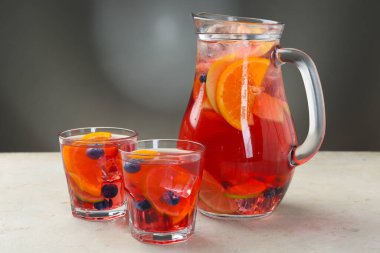 Açık gri desenli masada meyveli kokteyl.