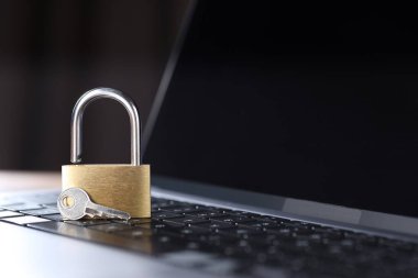 Siber güvenlik. Metal asma kilit ve anahtar bilgisayarda, yakın plan. Metin için boşluk