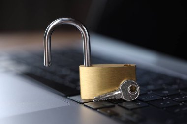 Siber güvenlik. Dizüstü bilgisayarda metal kilit ve anahtar, yakın plan.