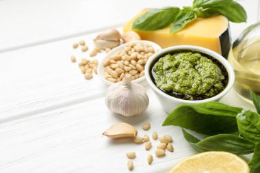 Tabakta taze pesto sosu ve beyaz ahşap masada malzemeler. Metin için boşluk