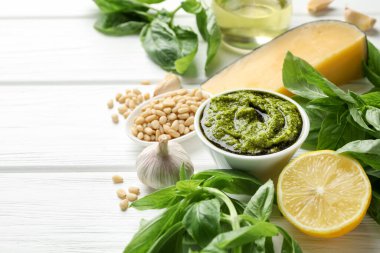 Tabakta taze pesto sosu ve beyaz ahşap masada malzemeler. Metin için boşluk