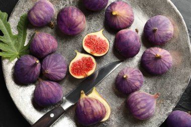 Taze incir, bıçak ve yeşil yaprak.