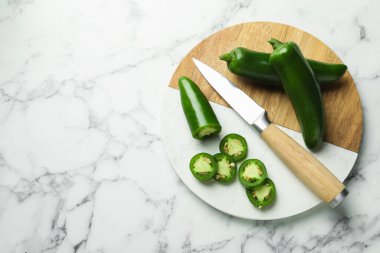 Olgun jalapeno biberleri ve beyaz mermer masa, üst manzara. Metin için boşluk