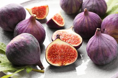 Taze incir ve yeşil yaprak masada, yakın plan.