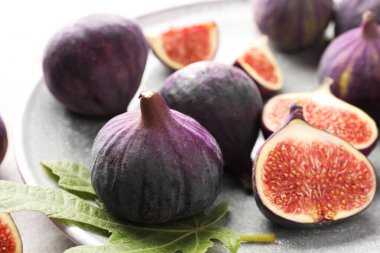 Taze incir ve yeşil yaprak masada, yakın plan.