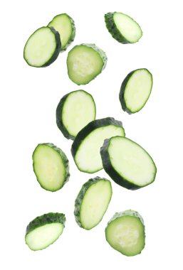 Beyaz arka plana düşen taze salatalık parçaları.