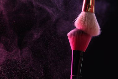 Siyah arka planda pembe göz farlı makyaj fırçaları, yakın plan. Metin için boşluk