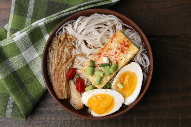 Ahşap masadaki kasede eno mantarlı lezzetli ramen.