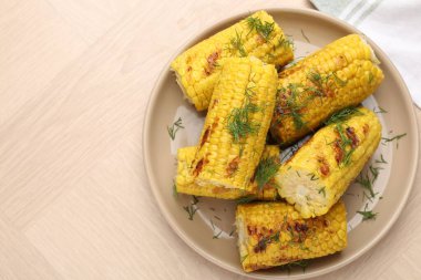 Ahşap masa üzerinde dereotlu mısır koçanı parçaları, üst manzara. Metin için boşluk