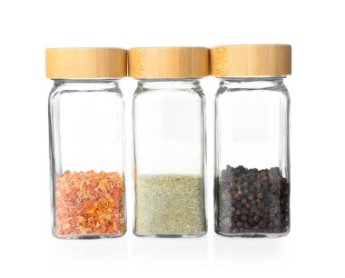 Beyaza izole edilmiş cam kavanozlardaki Aromatik baharatlar